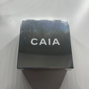 Translucent Matte Loose Setting Powder från CAIA - Säljer ett löst puder från CAIA i färgen Translucent Matte. Perfekt för att sätta sminket och ge en matt finish. Kommer i en stilren förpackning med spegelblankt lock. Locket är repigt och det är ungefär hälften kvar 