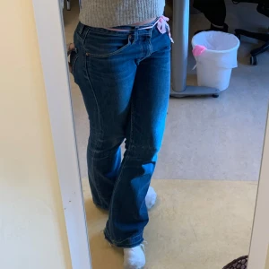 Blå levis bootcut jeans - Snygga blå bootcut jeans med låg midja. Perfekta för en avslappnad stil. De har en klassisk design med knappar och dragkedja framtill. vintage levis jeans. skicka om du har några frågor om mått eller så💞