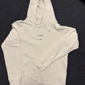 Beige hoodie från Les Deux - Säljer en stilren beige hoodie från Les Deux. Den har en klassisk design med justerbar huva och en praktisk magficka. Storlek S men är lite större. Väldigt bra skick. Ställ gärna frågor om det är något ni undrar.