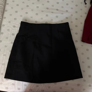 Svart kjol från Zara - Snygg svart kortkjol från Zara i klassisk design. Perfekt för att matcha med olika toppar och accessoarer.