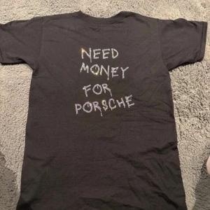 Bvaldi t-shirt - Svart t-shirt med texten 'NEED MONEY FOR PORSCHE' på baksidan och 'BV' på framsidan. Perfekt för en avslappnad stil.