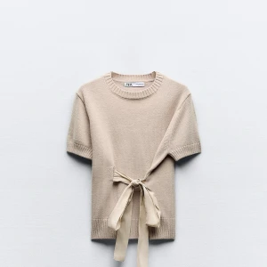 Beige kortärmad tröja från Zara - Snygg beige tröja från Zara med korta ärmar och en dekorativ knytning framtill. Perfekt för en stilren look. Bara att höra av sig för mer bilder❣️