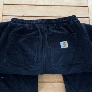 Manchesterbyxa från Carhartt - Mörkblå manchesterbyxa från märket Carhartt. Storlek S, fråga gärna om längd ifall du osäker. Skicket är använt, ett hål på vänster sida - se bild 4. 