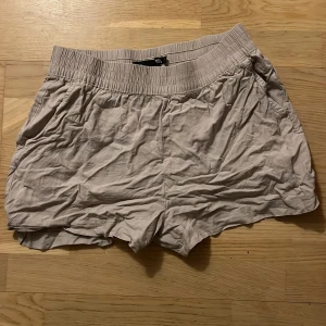 Beige shorts från lager 157 - Säljer ett par bekväma beige shorts från lager 157. De har en elastisk midja och praktiska fickor på sidorna. 