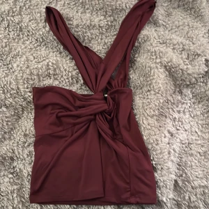 Vinröd topp från BikBok - Snygg vinröd topp från BikBok med knytning framtill. Perfekt för en stilren look med breda axelband som ger en unik touch. Själv klippta band 💕
