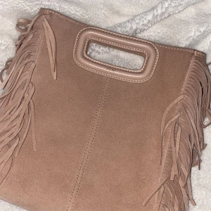 Maje Väska - Säljer nu min super snygga maje väska då den tyvärr inte kommer till användning💗Stora modellen i mocka färgen rosa! Lite defekter på baksidan av väskan men inget som stör och framsidan är som ny. Nypris 3000 och priset kan diskuteras✨ Studsbag och band till väskan tillkommer💖