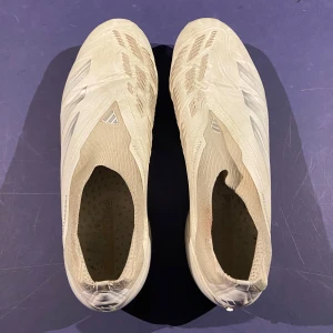 Vita fotbollsskor från Adidas - Snygga vita fotbollsskor från Adidas i storlek 44,2/3. Nypris 3000. Slitna längst fram på skorna men fungerar att spela i.