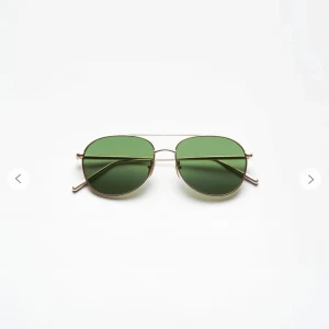 Solglasögon med gröna linser - Snygga solglasögon med gröna linser och en tunn guldfärgad metallram. Den klassiska designen ger en tidlös look, perfekt för soliga dagar. Passar både till vardag och utflykter.