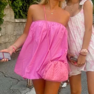 Rosa axelbandslös klänning - ‼️LÅNAD BILD‼️Skriv privat för egna bilder! Snygg rosa axelbandslös klänning i kort modell. Perfekt för varma sommardagar med en luftig passform. Enkel och stilren design som passar till många tillfällen. Endast använd en gång!