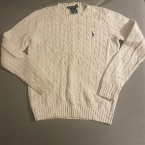 Polo Ralph lauren  - Säljer en riktigt fin kabelstickad Polo tröja i mycket bra skick. Tröjan har en liten defekt vid taggen. 