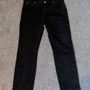 Svarta jeans från Lee - Snygga svarta jeans från Lee med klassisk femficksdesign och knappgylf. Perfekta för en stilren look. Passar både till vardags och mer uppklädda tillfällen.
