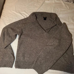 Grå tröja från Index - Säljer en stilren grå tröja från Index i storlek M. Tröjan har en klassisk krage och långa ärmar med ribbade muddar. Perfekt för kyligare dagar.