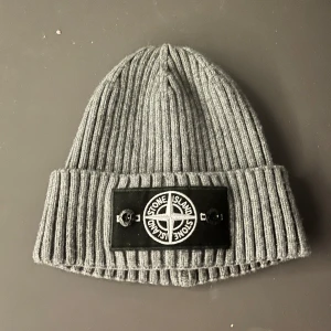 Grå stone island mössa - Säljer nu min stone island mössa som jag fick i julklapp, säljer pågrund av att jag har en annan, perfekt nu inför vintern när det börjar bli lite kyligare om huvudet, väldig fin och få gånger använd, kom privat så kan vi diskutera priset👍