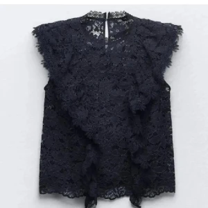 Mörkblå spetsblus - Elegant mörkblå spetsblus med volangdetaljer och ärmlös design. Nyskick!