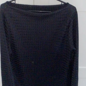 Svart ribbad tröja - Säljer en stilren svart ribbad tröja med långärmad design. Perfekt för kyligare dagar och enkel att matcha med olika outfits.