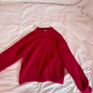 Röd tröja från H&M - Säljer en snygg röd tröja från H&M. Tröjan har en enkel design med långa ärmar och en klassisk passform. Perfekt för att hålla sig varm och stilren under kyligare dagar. Passar bra till både jeans och kjol.