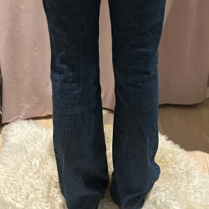 Blå bootcut jeans - Snygga blå bootcut jeans med hög midja och klassisk femficksdesign. Perfekta för en avslappnad stil med en touch av retro. Passar bra till både sneakers och klackar.