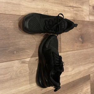 Svarta Nike sneakers - Snygga svarta Nike sneakers med en modern design. Skorna har snörning och en bekväm sula som ger bra stöd. Perfekta för både träning och vardag.