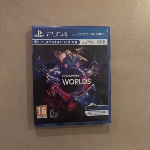 PlayStation VR Worlds för PS4 - Säljer spelet PlayStation VR Worlds för PS4. Det är ett VR-spel med flera olika upplevelser och äventyr. Perfekt för dig som vill utforska VR-världen med din PlayStation VR. Omslaget är i blått med en futuristisk design.