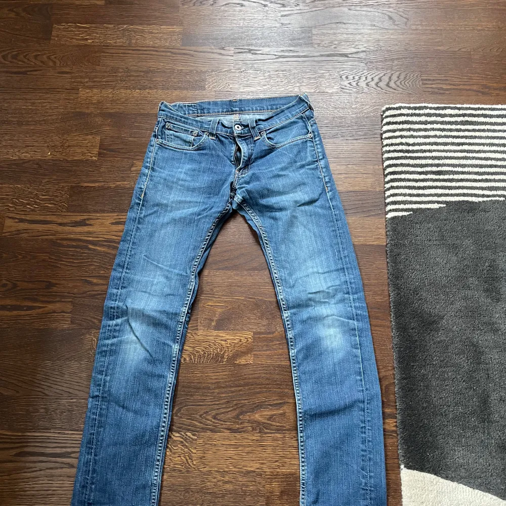 Säljer ett par klassiska blå Levi's jeans med fem fickor och knappgylf. De har en snygg tvätt och är perfekta för en avslappnad stil. Märkeslappen syns tydligt på baksidan. 511 slim fit storlek: 29:32. Farkut & Housut.