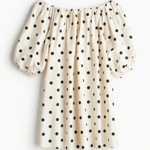 Prickig offshoulder klänning - Snygg offshoulder klänning med svart prickigt mönster på en vit bakgrund. Klänningen har puffiga kortärmar och en luftig passform, perfekt för en somrig look. Tillverkad i ett lätt och bekvämt material. Lapp kvar! Säljer få den va för stor för mig💖