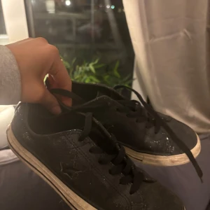 Glittee Converse - Säljer ett par svarta Converse sneakers med snörning. Skorna har en glittrig yta och en vit sula.  Mina favorit skor som tycärr är för små💕