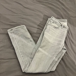 Ljusgrå Lee jeans  - Snygga ljusgrå jeansbyxor från Lee med klassisk femficksdesign. De har en rak passform och är tillverkade i ett bekvämt denimtyg. Perfekta för en stilren look. Modellen Daren zip fly storlek 33/32 
