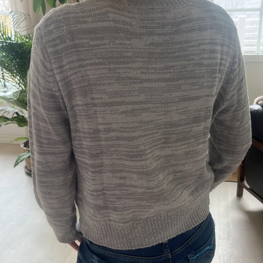 Säljer en stilren grå stickad tröja från Divided. Tröjan har ett klassiskt flätmönster och rund halsringning. Perfekt för kyligare dagar. Passar bra till jeans eller kjol. 🧶. Neuletakit & Villapaidat.