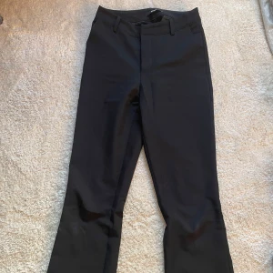 Svarta kostymbyxor från bikbok  - Säljer snygga svarta kostymbyxor från bikbok med en medelhög midja. De har en utsvängd passform och är perfekta för en stilren look. Har inte använts mycket alls så gott skick. 