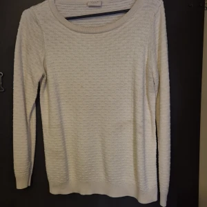 Vit stickad tröja från VILA - Säljer en stilren vit stickad tröja från VILA i storlek XL. Tröjan har en rund halsringning och långa ärmar, perfekt för kyligare dagar. Den har en subtil textur som ger en extra touch till designen. Passar bra till både jeans och kjol.