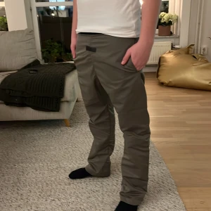 Byxor från Essentials Fear of God - Snygga byxor från Essentials Fear of God med en stilren design. Byxorna har en elastisk midja och en diskret logga framtill. Perfekta för en avslappnad och trendig look. Köpt i Tokyo 100 % äkta 