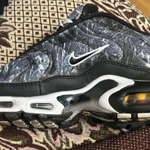 Nike Air TN med mönster - Snygga Nike Air TN med ett unikt mönster i svart och grått. Skorna har den ikoniska Air TN-dämpningen och en stilren design med snörning. Perfekta för dig som vill ha både stil och komfort.