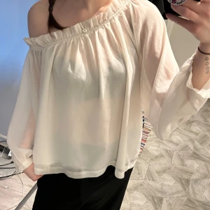 Vit offshoulder blus - Säljer en luftig vit offshoulder blus med långa ärmar i storlek 36. Perfekt för en avslappnad och stilren look. 💕