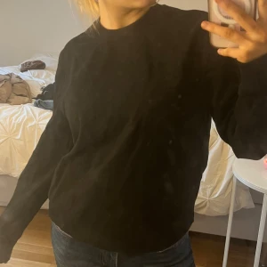 Svart tröja - Säljer en enkel och stilren svart tröja med normal passform. Tröjan har långa ärmar och rund halsringning, perfekt för en avslappnad look. Passar bra till jeans eller andra casual outfits.
