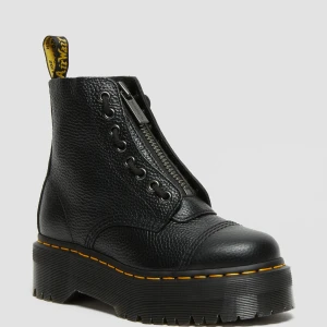 Dr. Martens Sinclair - Snygga svarta boots från Dr. Martens med dragkedja framtill och snörning. De har en robust platåsula och den klassiska gula sömmen runt sulan. Perfekta för en edgy look. I nyskick och använda ett fåtal gånger. Säljes då jag har ett par liknande och de kommer inte komma till användning. Nypris 2400kr. Säljes för 1500kr. Passar mig som har 36/37