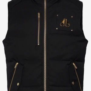 Moose knuckles westmount vest Gold - Nypris 7500kr oöppnad förpackning kvitto finns möts bara upp tar bara kontant skriv privat vid intresse🫡.Snygg svart dunväst med gulddragkedjor och detaljer. Västen har en dragkedja framtill och två fickor med dragkedjor. Perfekt för att hålla värmen med stil.