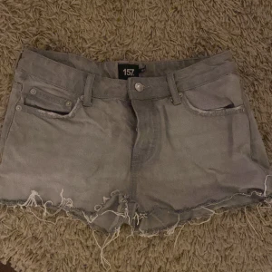 Grå jeansshorts från 157 - Snygga grå jeansshorts från 157 med fransiga kanter och klassisk femficksdesign. Perfekta för en avslappnad stil.