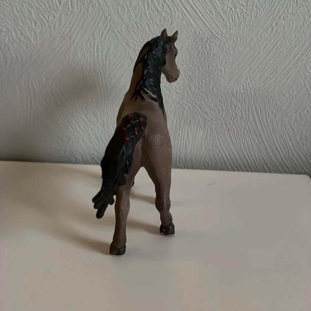 Detaljerad brun hästfigur med svart man och svans. Hästen har vita markeringar på benen och en elegant hållning. Perfekt för samlare eller som leksak för hästälskare.. Muu.