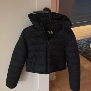 Svart pufferjacka från Zara - Snygg svart pufferjacka från Zara som är en kort modell! Perfekt för kyliga dagar. Jackan har en quiltad design och långa ärmar. Köpt för 400kr!💓storlek 13-14 år men skulle säga att den passar dem som har xs/s också! Är en kort modell!💓