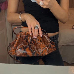Clutch väska 😍 - Såå snygg clutch väska med band i ormskinnsmönster 🥰❣️ väldigt rymlig och unik!!