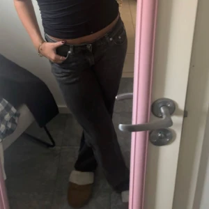 Svarta jeansbyxor - Snygga svarta jeansbyxor med låg midja. Perfekta för en avslappnad look. De har klassisk femficksdesign och knappar framtill.