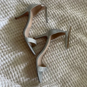 Glittriga silverpumps från Jenny Fairy - Snygga silverpumps från Jenny Fairy med glittrig yta och elegant klack samt öppen tå⭐️ använts en gång! (6 cm klack)
