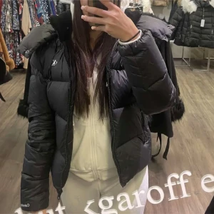 Svart dunjacka från Calvin Klein - Snygg svart dunjacka från Calvin Klein med dragkedja och hög krage. Jackan har en pufferdesign och är perfekt för kyliga dagar. Den har långa ärmar och en stilren look som funkar till det mesta. Perfekt för dig som vill hålla stilen i vinter.