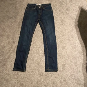 Levis 510 jeans i mörkblå denim - Snygga Levis 510 jeans i mörkblå denim med en skinny passform. Klassisk design med fem fickor och guldfärgade sömmar. Perfekta för en stilren look.