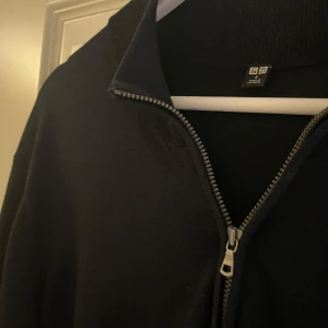 Mörkblå half-zip - Säljer en stilren marin blå tröja från Uniqlo med dragkedja. Tröjan har långa ärmar och en ribbad krage. Perfekt för en minimalistisk look. Tröjan har inga tecken på användning.
