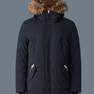 Svart Mackage parkajacka med pälsdetalj  - Snygg svart parkajacka med avtagbar huva och pälsdetalj. Jackan har dragkedja och praktiska fickor med dragkedjor. Perfekt för kyliga dagar. Storlek 42/52.. Kvitto finns. Oanvänd. Ordinarie pris: 16,000. 