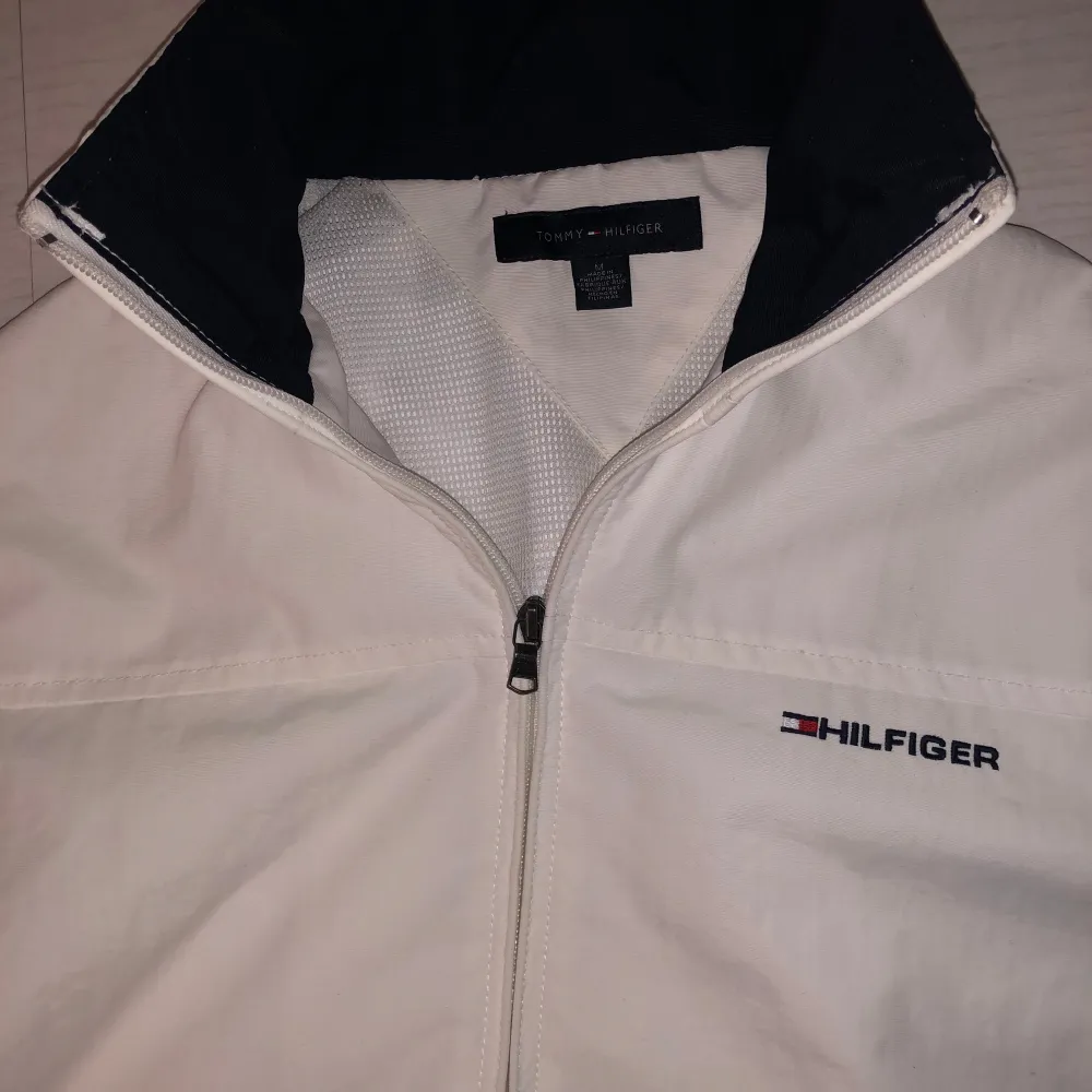 Säljer en vit vindjacka från Tommy Hilfiger med dragkedja och broderad logga på bröstet. Vid frågor eller fler bilder kontakta mig. Priset går att diskutera. . Takit.
