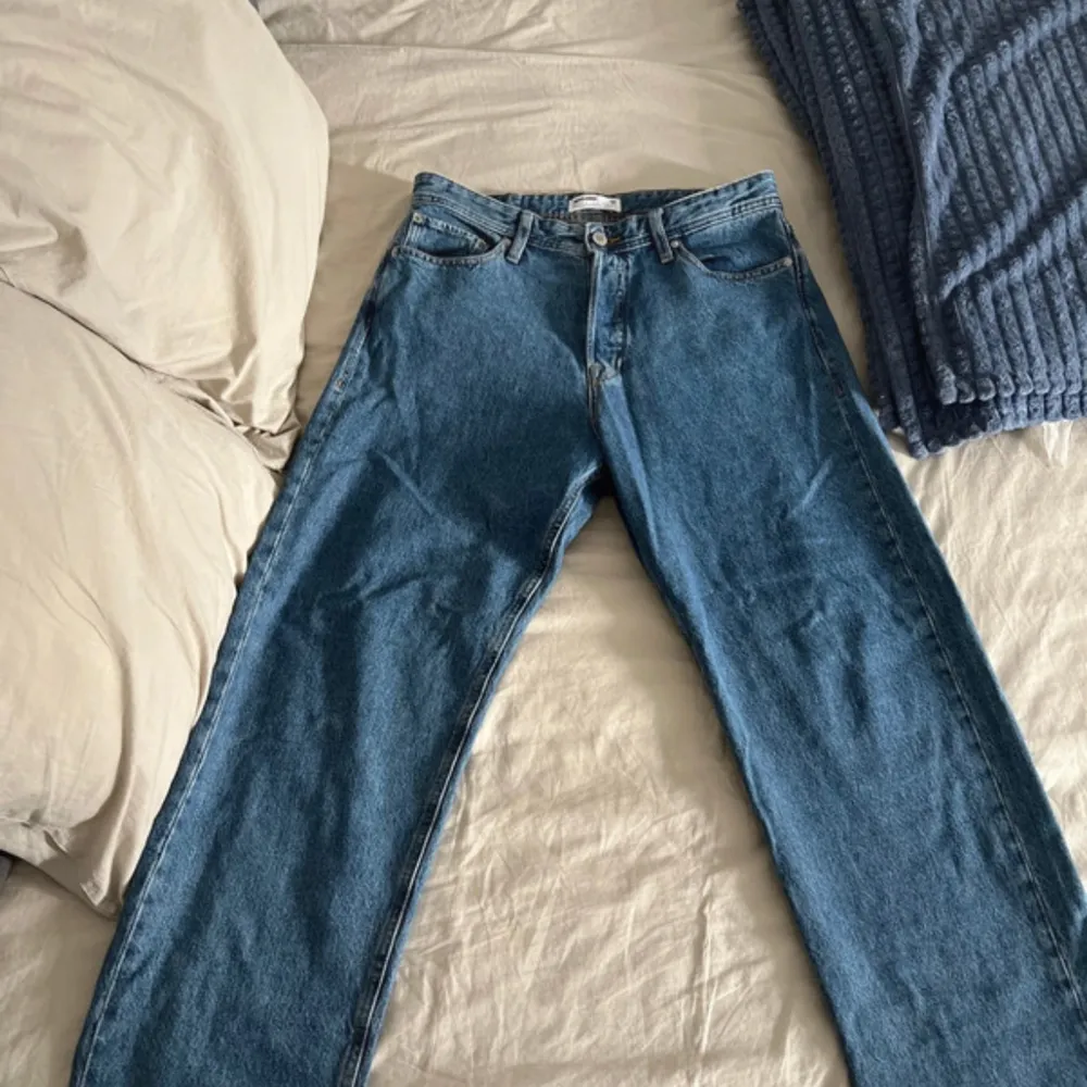 Säljer ett par klassiska blå jeansbyxor. De har en rak passform och är i ett robust denimtyg. Oversized jeans som är nya och aldrig använda men utan prislapp. . Jeans & Byxor.