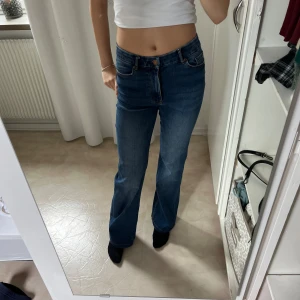 Blå utsvängda jeans  - Jättefina mörkblå utsvängda jeans. Använda fåtal gånger, ser helt nya ut. De är uppsydda. Storlek 36 men har storlek 34 och de är lite stora. Väldigt stretchiga skulle säga att de passar 32,34,36. Köpta för 600.