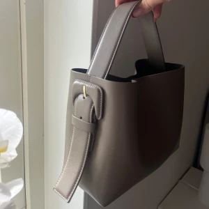 Arket väska  - Superfin väska från arket! Mullvadsgrå färg som är slut på deras hemsida! Köptes i april detta året i arkets butik. Nyskick! Tillkommer även ett längre band, se sista bilden. Nypris 2000kr 💝